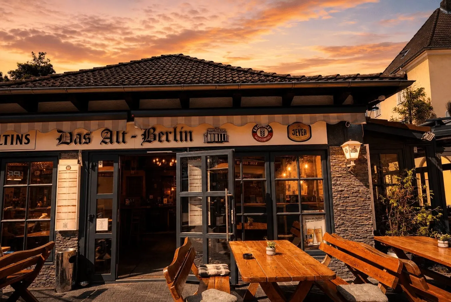Das Alt-Berlin bei Sonnenuntergang – Eingang mit Schriftzug und Biergarten
