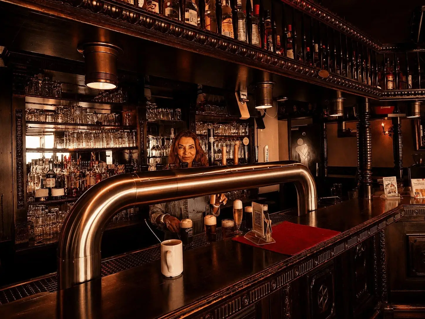 Barkeeperin zapft frisches Bier an der klassischen Bar